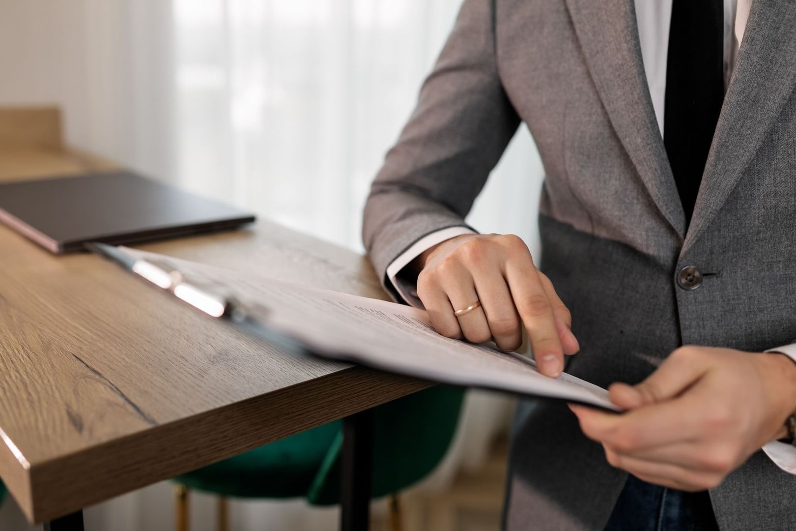 Personne en costume consultant des documents administratifs à un bureau